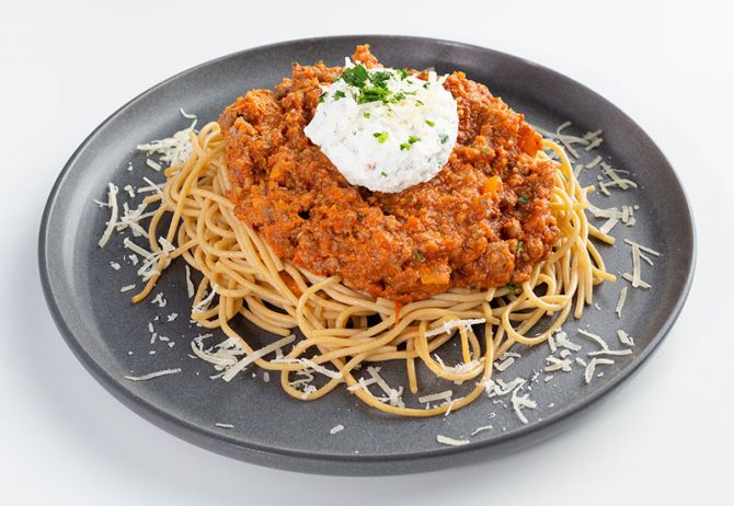 spartan meal preps miami - beef bolognese paired with pasta and cream on plate with cheese all over. Healthy meal from spartan meal preps miami.