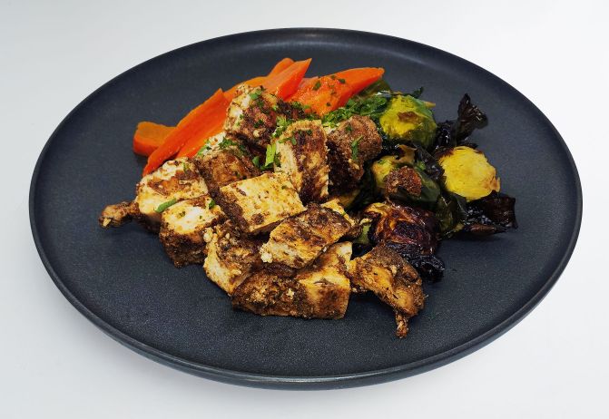 Spartan meal preps miami - jerk chicken with veggeis on a plate. Healthy dish from spartan meal preps miami.