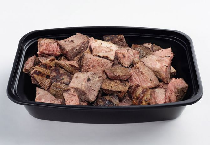 A black plastic container filled with chopped grilled sirloin steak.