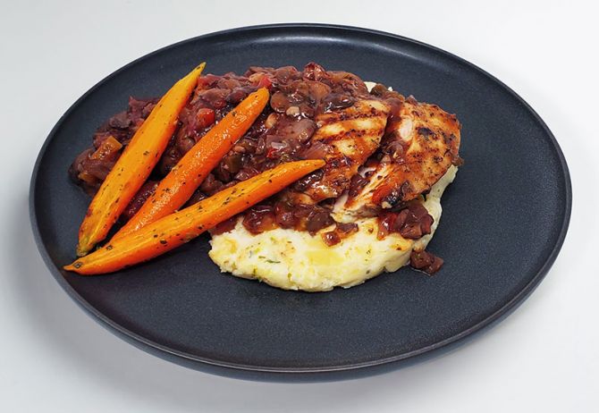 chicken cacciatore spartan meal preps chicken with sauce paired with orange carrots and soft mashed potatoes.