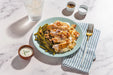 Plate of food with green beans and a side of sauce on a marble surface