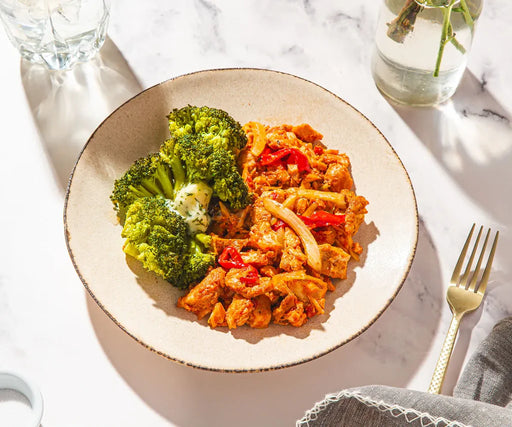 Plate of food with broccoli and scrambled eggs on a marble surface