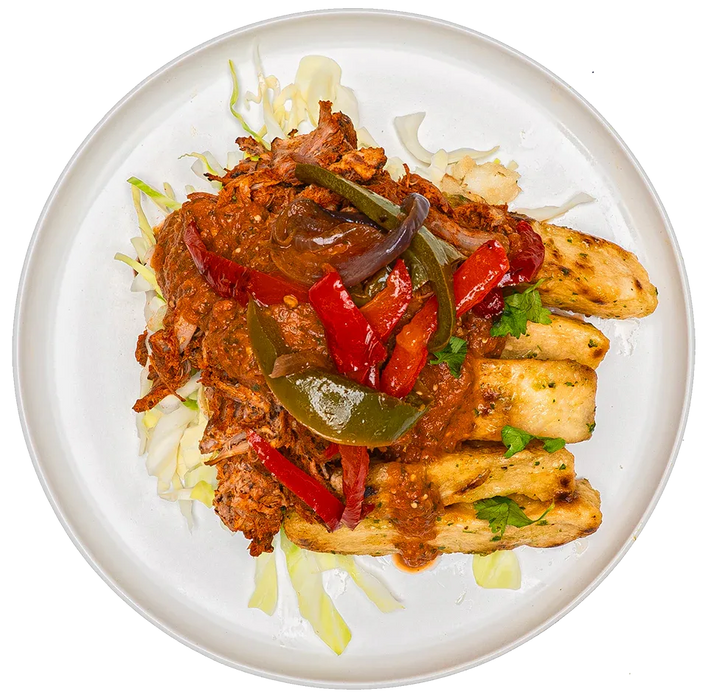 Plated dish with chicken, vegetables, and sauce on a white background