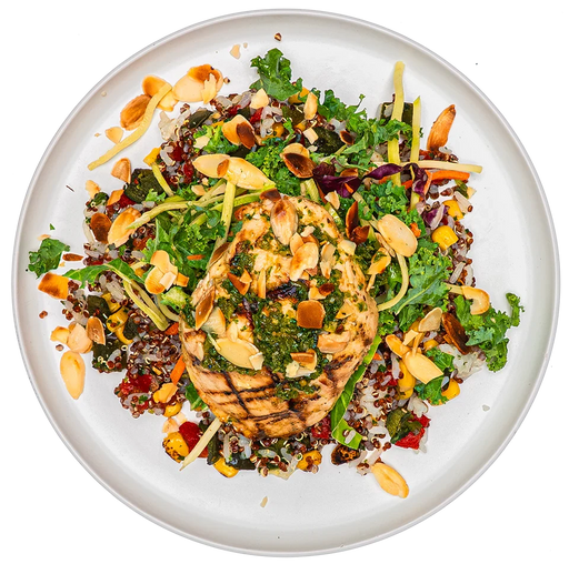 A top-down view of a plated prepared food dish featuring a grilled chicken breast topped with green herbs, served over a bed of mixed greens, quinoa, shredded carrots, and sliced almonds on a white plate.