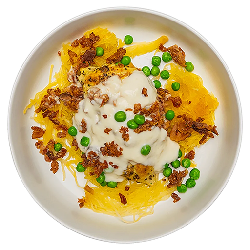 Plated dish with yellow noodles, green peas, croutons, and a white sauce on a white plate.
