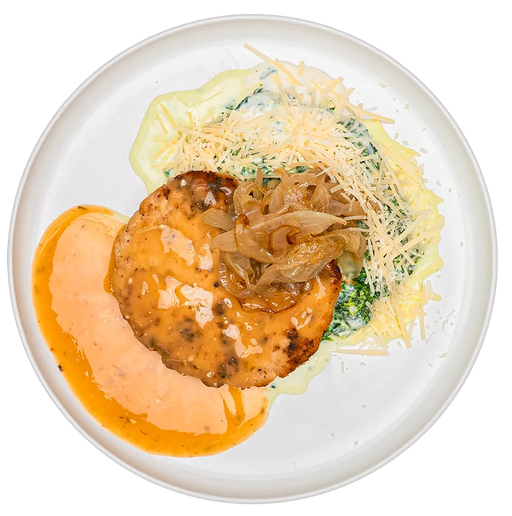 Plated dish with a meat patty, sauce, and garnishes on a white plate