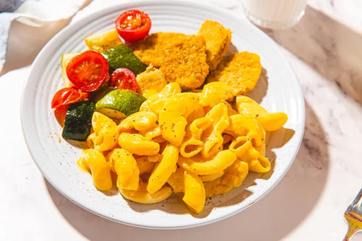 Plate of pasta with vegetables on a marble surface