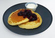 spartan meal preps miami - blueberry pancakes serviced on a blue dish with house sauce next to it. Healthy meal from Spartan Meal Preps Miami.