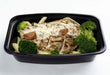 Prepared meal with chicken, broccoli, and pasta in a black tray.