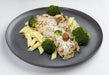 A plate of Roma Grilled Chicken Pasta with penne pasta, flame grilled chicken, roasted broccoli, and shaved Parmigiano Reggiano.